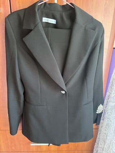 kompleti zenski: Elegantno žensko odelo u crnoj boji, sastavljeno od sakoa i pantalona — 1
