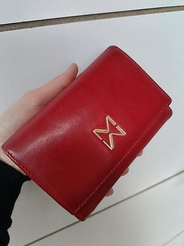 Ženski crveni novčanik od glatke kože, kompaktne preklopne forme. Na