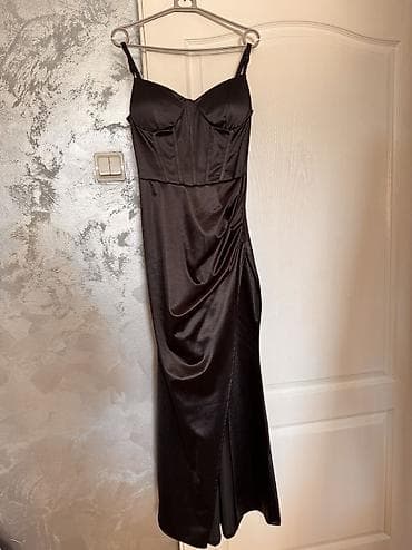 Crna elegantna haljina 
prati liniju tela