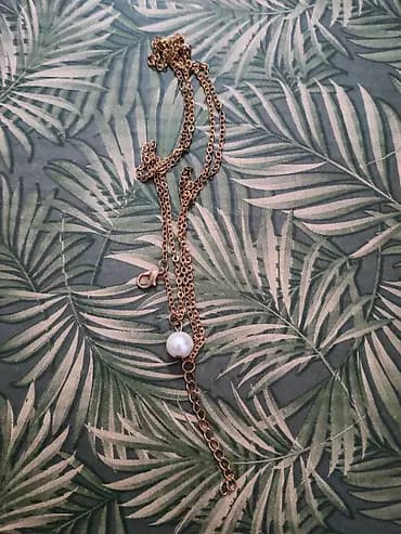 Elegantna ogrlica sa zlatno-toniranim lancem i belim bisernim