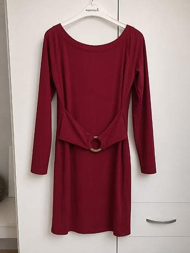 Elegantna bordo haljina sa dugim rukavima i ukrasnim pojasom. Model je na lalafo.rs Elegantna bordo haljina sa dugim rukavima i ukrasnim pojasom. Model je