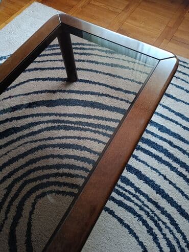 Drveni stabilni sto. Tamnobraon boje. Na sredini deblje sivo staklo na lalafo.rs Drveni stabilni sto. Tamnobraon boje. Na sredini deblje sivo staklo