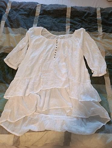 Bela ženska bluzica/tunika od laganog, prozračnog materijala. Model je na lalafo.rs Bela ženska bluzica/tunika od laganog, prozračnog materijala. Model je