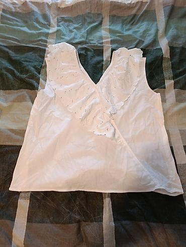 Bela ženska bluza/majica bez rukava sa V-izrezom. Napred ima ukrasne na lalafo.rs Bela ženska bluza/majica bez rukava sa V-izrezom. Napred ima ukrasne