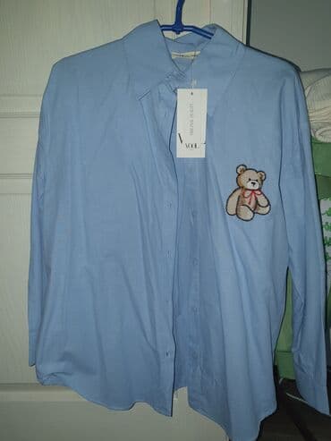 Plava košulja sa dugmićima i kragnom, klasičnog kroja. Na levoj strani na lalafo.rs Plava košulja sa dugmićima i kragnom, klasičnog kroja. Na levoj strani