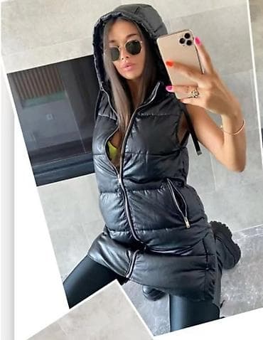 Duga ženska prsluk-jakna bez rukava, crne boje, sa kapuljačom. Model na lalafo.rs Duga ženska prsluk-jakna bez rukava, crne boje, sa kapuljačom. Model