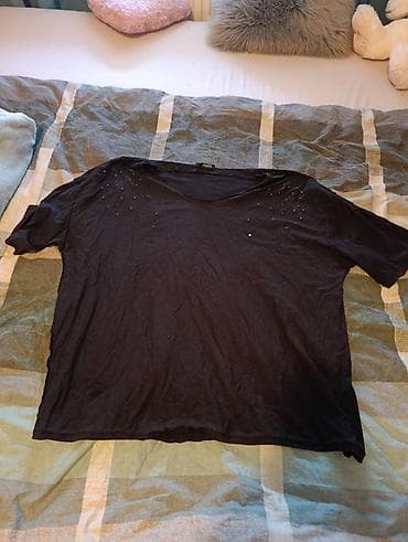 Crna ženska majica sa kratkim rukavima i okruglim izrezom. Model je na lalafo.rs Crna ženska majica sa kratkim rukavima i okruglim izrezom. Model je